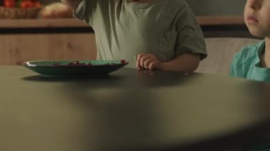 Bebek, mutfak masasında kardeşiyle dizüstü bilgisayarda film izlerken tabaktan nar tohumu yiyordu. Çocuk müptelası çizgi film