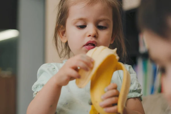Menina Feliz Bebê Comendo Banana Casa Uma Menina Comer Banana — Fotografia de Stock