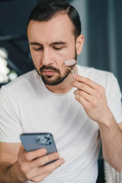 Bearded Man Använder Jade Ansikte Roller Hemma För Skönhet Ansiktsmassage — Stockfoto