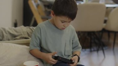 Beyaz çocuk evinde dinlenirken kasten siyah plastik bir nesneyi inceliyor. Mutlu, neşeli bir aile. Tatlı çocuk, oyun oynuyor..
