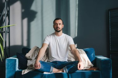 Nilüfer çiçeğinde meditasyon yapan, derin nefes alan ve rahat bir koç gibi rahat rahat oturan bir adam. Stressiz hissetmek.