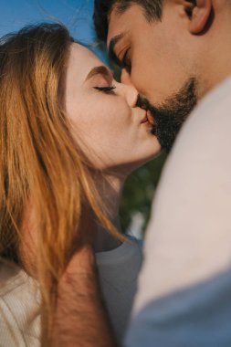 Adam doğada romantik bir buluşma sırasında kız arkadaşını nazikçe öpüyor. Birlikte eğleniyoruz. Tutku.