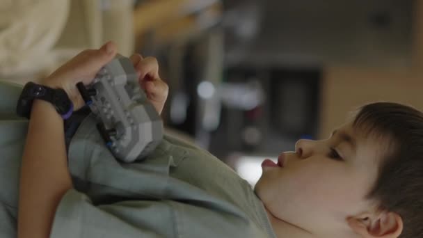 自宅でレゴのおもちゃの屋内で遊んでかわいい男の子の垂直シーン 高品質4K映像 — ストック動画