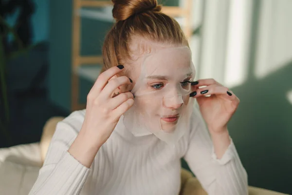 Pozytywna Młoda Kobieta Ubraniu Casual Stosowania Maski Twarzy Jasnym Salonie — Zdjęcie stockowe