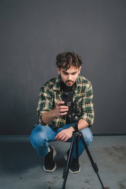 Yakışıklı genç adam sosyal medya için dans videosu kaydetmek için akıllı telefon kuruyor. Siyah arka planda izole edilmiş. Yaratıcı insanlar. İnternet