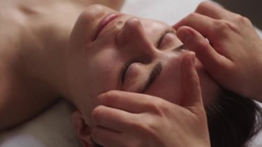 Relaxing beautiful woman having a massage for her skin on a face in beauty salon. Beauty treatment skincare. Beautiful young lady.