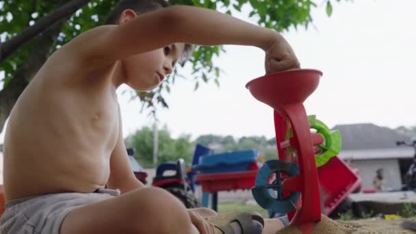 Zijaanzicht Van Een Jongen Die Zand Een Plastic Machine Buiten — Stockvideo