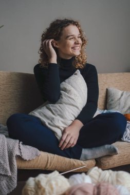 Evdeki kanepede uzanan genç ve güzel bir kadın vücuduna yakın yastık tutuyor. İyi ki sıkı bir haftadan sonra dinleniyor. Modern tarz. Ev istirahatı.