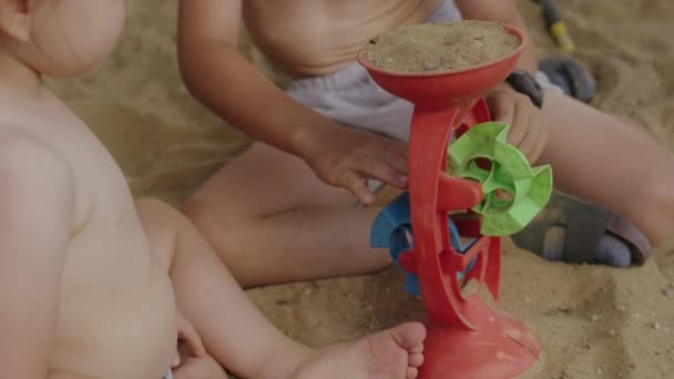 2人の幸せな小さな子供は さまざまなカラフルな砂のおもちゃで遊んでいます 楽しさと楽しさで休日を過ごしています アクティブ サマー ゲーム — ストック動画