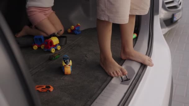 Testvérek Ülnek Egy Autó Csomagtartójában Műanyag Autókkal Játszanak Miközben Arra — Stock videók