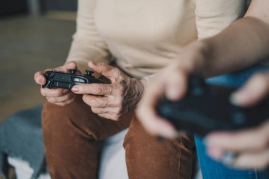 Oyun konsolu joystickleri kullanan son sınıf kadın elleri, sanal oyuncu, aile eğlencesi, eğlenceli oyun zamanı..