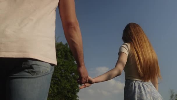 春の庭を歩くカップルが手を握っています 愛のコンセプト フォトセッション — ストック動画