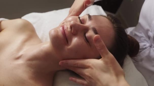 Hermosa Mujer Disfrutando Masaje Facial Con Los Ojos Cerrados Salón — Vídeo de stock