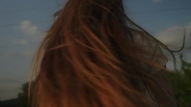 Kızıl saçlı kadın temiz hava soluyor, doğada yürüyor kırsalda özgürlüğü hissediyor. Doğal güzellik zencefili, tadını çıkarıyor. Keyifli bir gün.