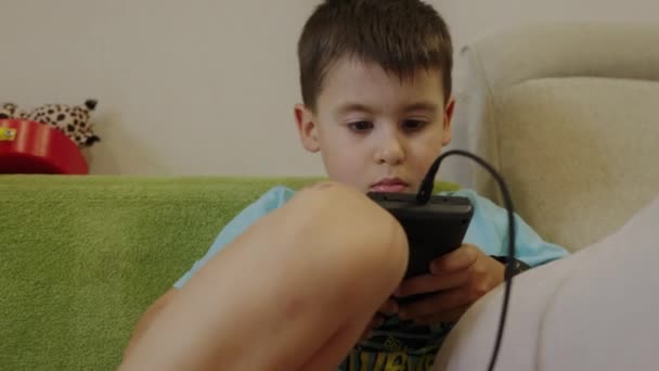 Rapaz Caucasiano Cavar Com Uma Consola Portátil Sofá Excitação Esgotamento — Vídeo de Stock