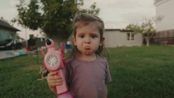 乡村花园的小女孩抱着吹泡机的泡沫 — 图库视频影像