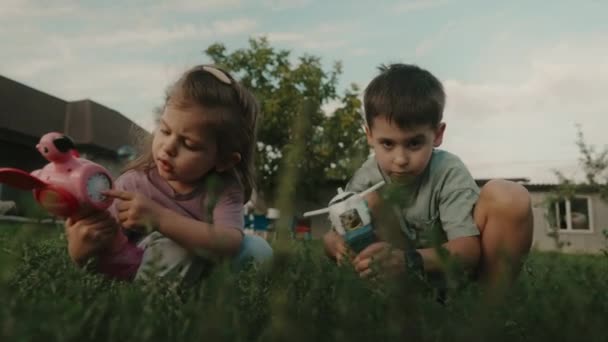 Hava Tabancasından Çıkan Sabun Baloncuklarıyla Oynayan Iki Çocuğun Görüntüsü Yazın — Stok video