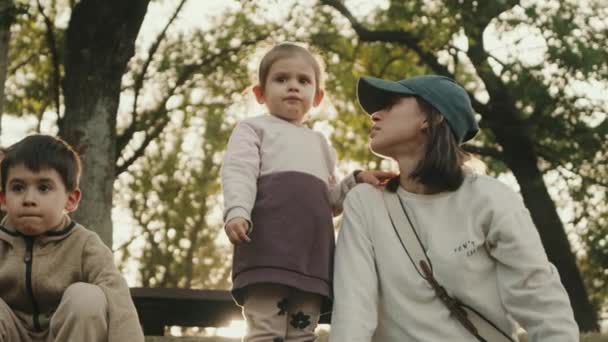 母親と一緒に公園で過ごした小さな男の子と少女 アウトドアで遊ぶ幸せな家族 — ストック動画