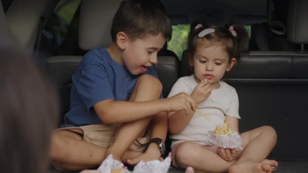 Kleine Kinderen Zitten Met Moeder Kofferbak Fastfood Eten Twee Schattige — Stockvideo