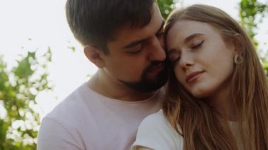 Kapalı gözlerle birbirine aşık genç çiftlerin yakın çekimleri. Yaz akşamları dışarıda birbirlerine sarılıyorlar. Romantik randevu kavramı açık havada aşk.