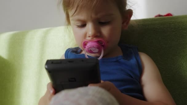 ポータブルビデオゲームコンソールで遊んでいる小さな赤ちゃんの女の子 キッズ中毒 — ストック動画