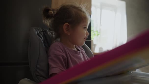 自宅で高い椅子に座っている間 彼女の赤ん坊の女の子にスプーンを与える未知の母親 — ストック動画