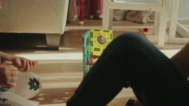 Çok neşeli küçük çocuklar yerde oyuncak oynuyorlar, eğleniyorlar, oturma odasında eğleniyorlar..