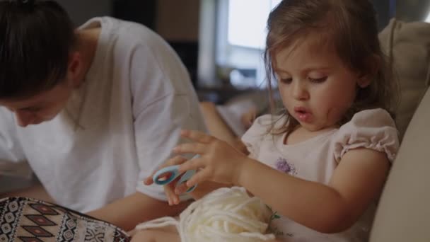 Κορούλα Κάθεται Στον Καναπέ Δίπλα Στη Μητέρα Της Κρατώντας Ένα — Αρχείο Βίντεο