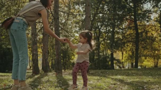 Anne Küçük Kızına Meşe Palamudunu Nasıl Tekmeleyeceğini Gösteriyor Sonbahar Parkında — Stok video