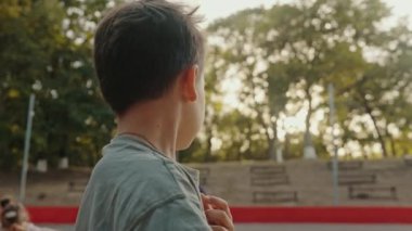 Yazın parkta bisiklet süren mutlu beyaz çocuk..