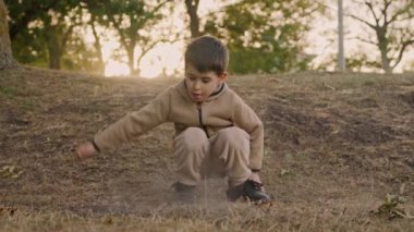 Küçük çocuk dalla oynuyor ve bahar sabahının erken saatlerinde ormanda eğleniyor. Çocuklar için etkinlik. Çocuklu aileler için açık hava eğlencesi