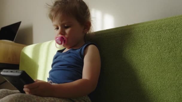 可爱的小女孩坐在家里沙发上玩Pc视频游戏的小玩艺儿 — 图库视频影像