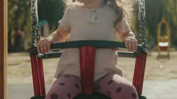 Щаслива Красива Дівчинка Розважається Гойдалках Дитячому Майданчику Активна Дитина Барвистих — стокове відео
