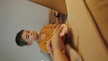 Laptop ekranı arayan ve ödev yapan beyaz bir çocuk masada oturuyor. Evdeki dizüstü bilgisayarda internette sörf yapan sevimli bir çocuk.