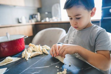 Akşam yemeği için hamur köftesi yontan sevimli bir çocuk. Çocuk mutfağa yardım ediyor. Annenin küçük yardımcısı..