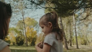 Anne ve kızı çam ormanında külah topluyor. Mutlu aile kavramı