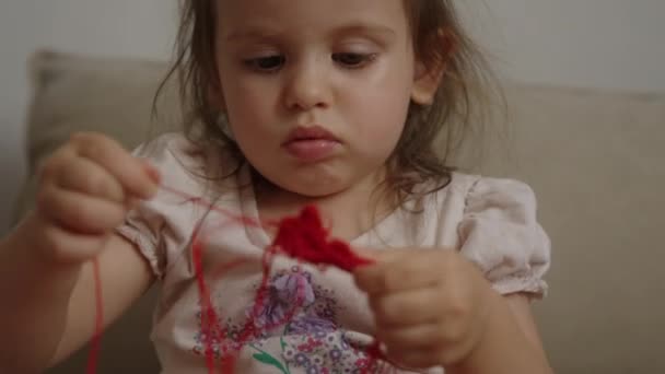 Kafkasyalı Küçük Kız Kırmızı Yün Toplarla Oynuyor — Stok video