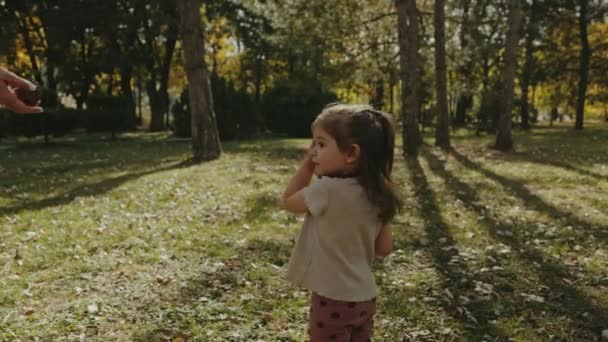 Anne Kızına Kozalağı Ayağıyla Itmeyi Öğretiyor Parkta Birlikte Eğleniyor Külahları — Stok video