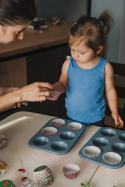 stock image A little cute girl and her mother preparing the dough for baking cake in the kitchen at home, happy family concept. Having fun together while enjoying freshly