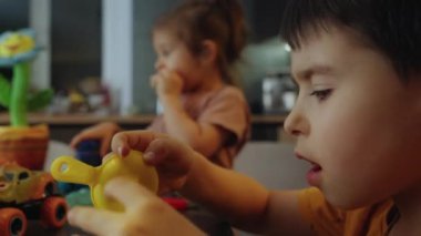 Evde araba oyuncaklarıyla oynayan pozitif erkek ve kız kardeşler. Çocuk oyunu kavramı işte. İnce motor becerilerin gelişimi