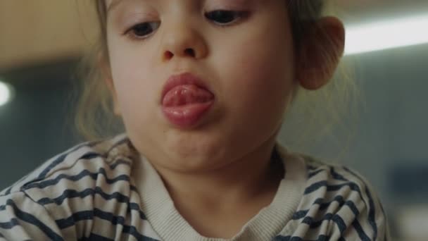 Zbliżenie Małej Dziewczynki Robiącej Interesującego Mima Wystającym Językiem Modelującej Coś — Wideo stockowe