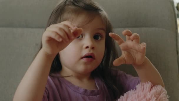 Забавная Маленькая Девочка Показывает Жесты Сидя Дома Одиночестве — стоковое видео