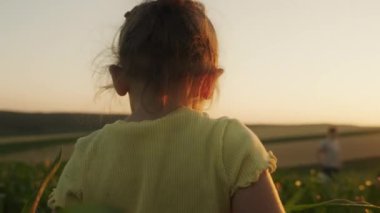 Mısır tarlasında sıradan kıyafetlerle dolaşan mutlu küçük bir kız. Olumlu duygular, çocukluk fikri.