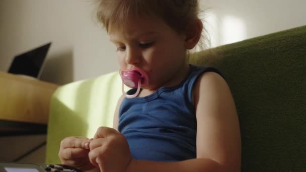 小女孩在沙发上玩一个带有便携式视频控制台的电子游戏 — 图库视频影像