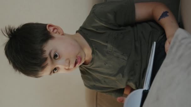 Preteen Boy Membaca Santai Sofa Ddoing Pekerjaan Rumah Ruang Tamu — Stok Video