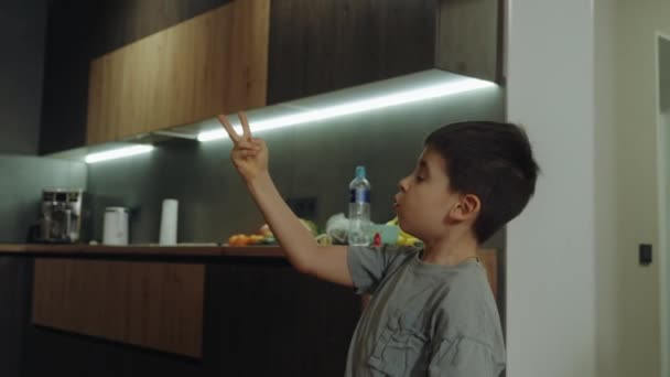 Guapo Niño Alegre Amistoso Gesticulando Con Los Dedos Usando Camiseta — Vídeo de stock