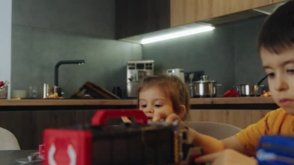 Erkek Çocuk Kız Kardeşinin Yanında Oturup Oyuncak Pistiyle Oynuyor Harekete — Stok video