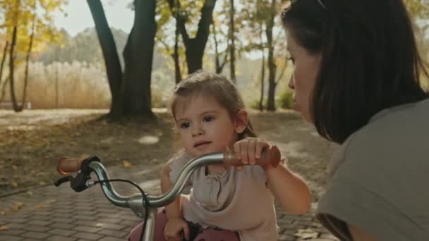 어머니 자전거를 그녀의 귀여운 가르치는 배경에 — 비디오