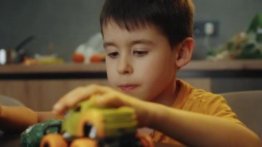 Evde çocuk oyuncaklarıyla oynayan küçük bir çocuk. Çocuk oyuncakları masada..