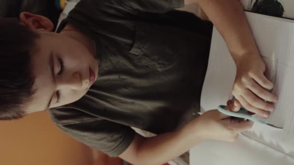 Kind Snijden Wit Papier Met Een Schaar Aan Tafel Woonkamer — Stockvideo